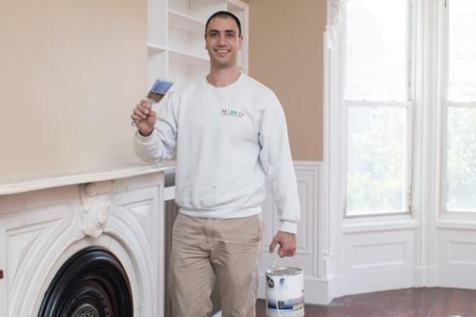 a man holding a brush and can of paint